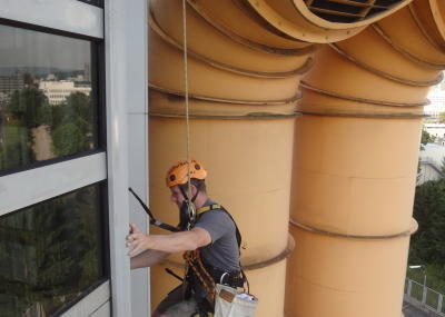 Fassadenkletterer bei Glasreinigung am hängenden Seil, Arbeit am Seil in der Höhe
