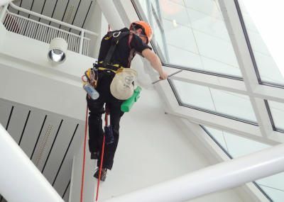Industriekletterer bei Glasreinigung am hängenden Seil, Arbeit am Seil