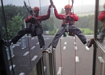 Fassadenkletterer bei Glasreinigung am hängenden Seil, Arbeit am Seil