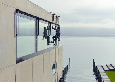 Glasreinigung am Seil in der Höhe, Gebäudereinigung mit Fassadenkletterer und Arbeit am Seil